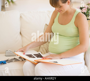 Schwangere Frau setzen Ultraschall im Fotoalbum Stockfoto