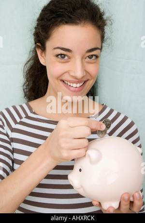 Frau ins Sparschwein Münzen Stockfoto