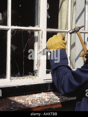 Nahaufnahme des Mannes ausschlagen Fensterscheibe vor dem Austausch mit Neuglas Stockfoto