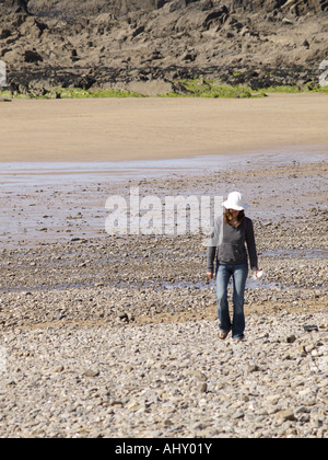 Erwachsenes Weibchen tragen weiße Sonnenhut, Jeans und Kapuzenpulli am Strand Stockfoto