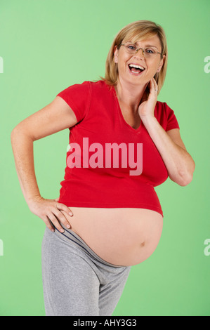 ATTRAKTIVE GESUNDEN SCHWANGEREN FRAUEN TRAGEN BRILLEN UND LACHEN Stockfoto