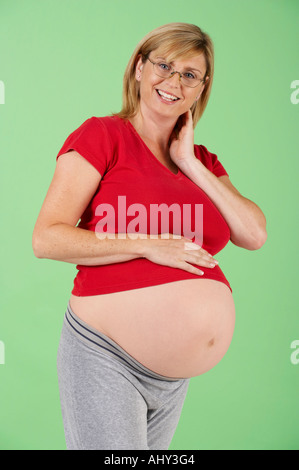 ATTRAKTIVE GESUNDEN SCHWANGEREN FRAUEN TRAGEN BRILLEN UND LACHEN Stockfoto