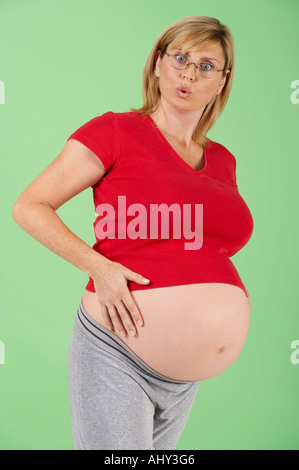 ATTRAKTIVE GESUNDEN SCHWANGEREN FRAUEN TRAGEN BRILLEN MIT AUSDRUCK VON ÜBERRASCHUNG Stockfoto