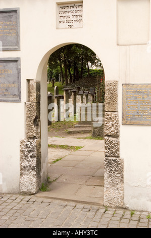 Bogenförmiger Eingang zum alten jüdischen Remuh-Friedhof in Kazimierz, Krakau, Polen, mit Steintafeln und historischen Grabsteinen im Hintergrund. Stockfoto