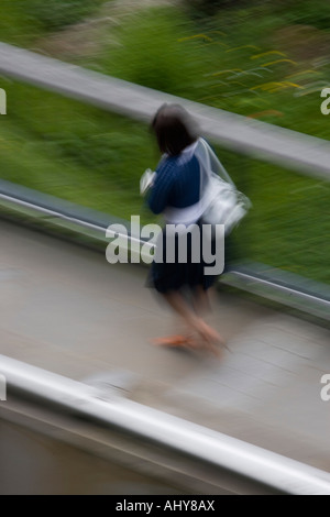 Overhead verschwommen Blick auf weibliche entlang der Fahrbahn in der City of London, Großbritannien. Stockfoto