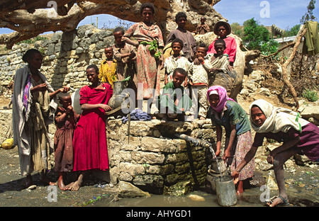 Frauen und Kinder sammeln frisches Wasser aus einer Gemeinschaftsquelle. Shoa, Äthiopien Stockfoto