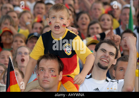 Junge beobachten Fußballspiel in Menge Stockfoto