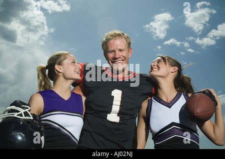 Fußball Spieler umarmt Cheerleader Stockfoto