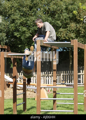 Zwei Jugendliche spielen auf dem Klettergerüst in ein Kinderspielplatz Stockfoto