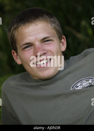 Teenager, Jeans und t-Shirt, ein Rasen-Bank, outdoor, Handauflegen, Lächeln, lachen und Blick in die Kamera Stockfoto