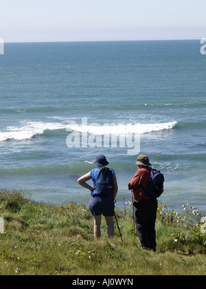 älteres Ehepaar in Wanderbekleidung stehend auf den Klippen über dem Meer, mit Blick Stockfoto