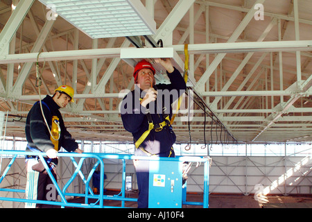 Elektriker arbeiten aus einem Cherrypicker Gesundheit Sicherheitsvorschriften Stockfoto