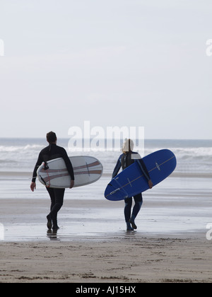 Zwei Surfer zu Fuß in Richtung Meer mit ihrem Surfbrett unter dem Arm Stockfoto