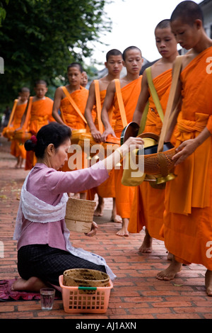 Einheimische Frau verleiht Mönche in Luang Prabang Laos Reis Alms Stockfoto