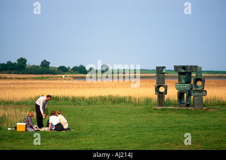 Menschen mit einem Picknick neben einem Henry Moore Bronzeskulptur, Snape Maltings, Suffolk Stockfoto