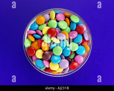 SCHÜSSEL MIT SMARTIES AUF BLAUEM HINTERGRUND Stockfoto