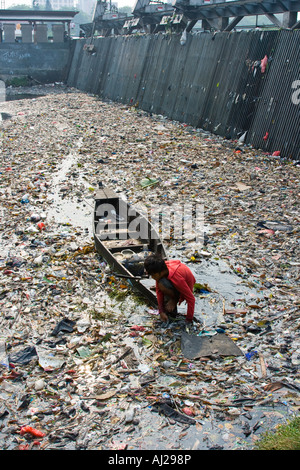 Junger Mann Kommissionierung durch Ciliwung Fluß der Müll für die Brocken von Wert Jakarta Indonesien Stockfoto