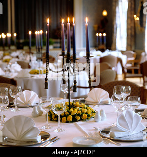 Tabellen mit brennenden Kerzen in den großen Speisesaal eines historischen deutschen herrschaftlichen Hauses gelegt Stockfoto