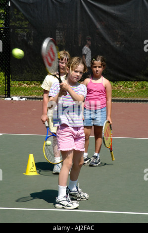 Die Kinder lernen, spielen Sie Tennis auf öffentliche Erholung Gericht Stockfoto