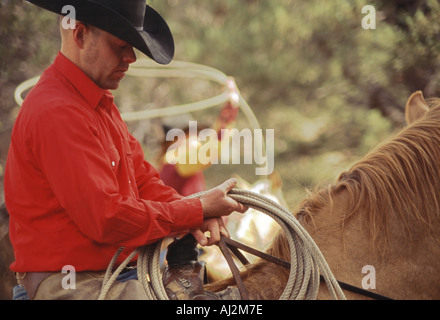 Cowboy im Vordergrund halten Seil auf dem Pferderücken und Cowgirl wirbelnd Lasso im Hintergrund in Oregon Stockfoto