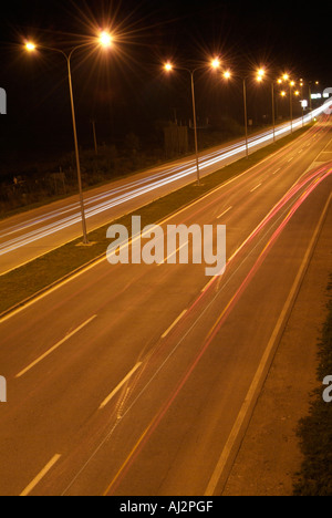 Zwei-spurige Autobahn spät in die Nacht mit Licht wegen der Fahrzeuge, die entlang der Straße Stockfoto