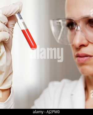 Nahaufnahme von einer Wissenschaftlerin, die Flüssigkeit in ein Reagenzglas zu untersuchen Stockfoto