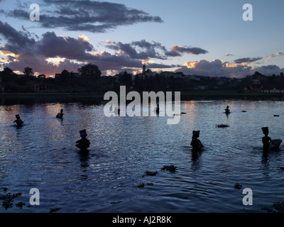 Männer-Fisch in Antsirabe See in der Abenddämmerung mit traditionellen Fischerei Weidenkörbe. Stockfoto