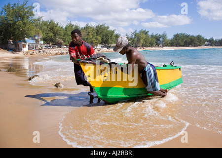 Fischer schleppen ihr Boot bis an den Strand in Tofo, in der Nähe von Inhambane im südlichen Mosambik. Stockfoto