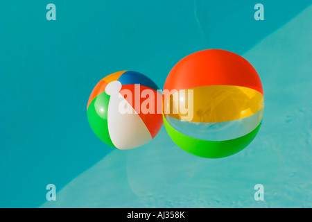 Zwei bunte Wasserbälle in einen Pool voller blauen Wasser schweben Stockfoto