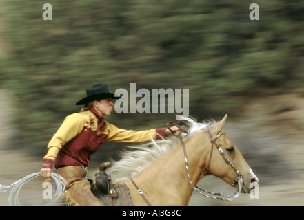 Cowgirl läuft auf einem Palomino-Pferd mit voller Geschwindigkeit in den Bergen von Oregon Stockfoto