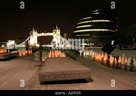 City Hall und Tower Bridge durch Brunnen am Südufer der Themse in London Uk in der Nacht gesehen Stockfoto