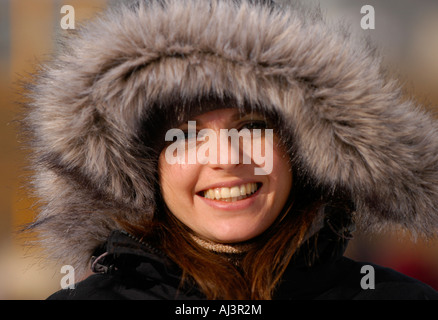 Ein lächelndes Mädchen tragen einer Jacke mit Fell gefütterte Kapuze Stockfoto