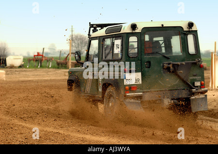 Land Rover Classic Defender langes Fahrwerk, das sich in schlammigem Gelände schnell dreht Stockfoto