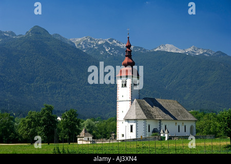 Die Kirche in Bitjne in der Nähe von Bohinj See sticht in krassen Schönheit gegen die umliegenden Berge Stockfoto