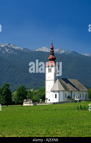 Die Kirche in Bitjne in der Nähe von Bohinj See sticht in krassen Schönheit gegen die umliegenden Berge Stockfoto