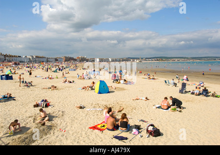 Eine Weitwinkelaufnahme einer typischen englischen Strand-Szene auf die sandige Bucht bei Weymouth. Stockfoto