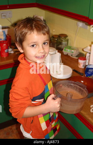 Kleiner Junge macht einen Schokoladenkuchen in der Familienküche Stockfoto