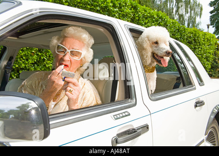 Ältere Frau Auftragen von Lippenstift in Auto Stockfoto