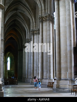 Die Kathedrale von Reims: eine Frau und Kind zu Fuß entlang eines die Gänge nach oben bewundern und beeindruckt von gotischen gewölbte Gewölbe, Reims, Champagne, Marne, Ardennen, Frankreich, niedrigen leicht körnig Korn Stockfoto