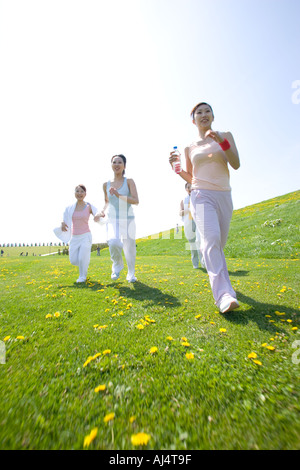 Vier junge Frau, die in Feld Stockfoto