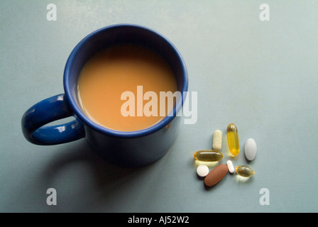 Vitamin Pillen, Kapseln und Medikamente mit einer Tasse Tee Stockfoto