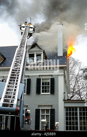 Feuerwehrleute kämpfen ein Haus Feuer vom Leiterwagen Stockfoto