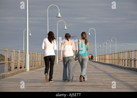 Drei Mädchen oder Frauen zu Fuß auf alten hölzernen Pier in Coffs Harbour in New South Wales NSW Australia NAOH CJWH Stockfoto
