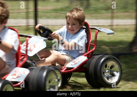 Kleiner junge Kind fahren Rennen Go Kart im Freien mit Motion blur in Coffs Harbour in New South Wales NSW Australia CJWH Stockfoto