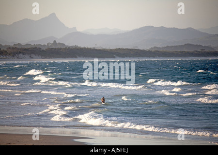 Romantisches Paar küssen im Meer am Strand von Belongil mit fernen Berge im Abendlicht Byron Bay New South Wales NSW Austr Stockfoto
