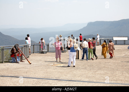 Menschen beobachten Aborigines Mann spielen Didgeridoo bei Lookout Three Sisters in den Blue Mountains New South Wales NSW Australia Stockfoto