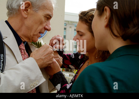 Töchter helfen Vater seinen Anzug außereuropäischen Stadt Beglückung Brighton Sussex England Knopfloch zuordnen Stockfoto