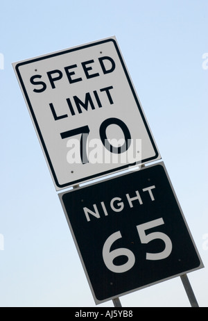 Das Texas-Geschwindigkeitsbegrenzungsschild zeigt 70 km/h tagsüber und 65 km/h nachts an einem ländlichen interstate Highway in den USA. Stockfoto