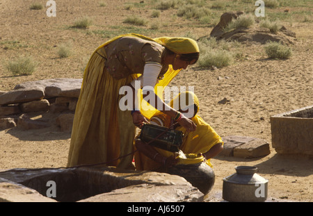 Rajasthani-Frauen holen Wasser aus einer Wüste weit außerhalb Jaisalmer, Indien. Stockfoto