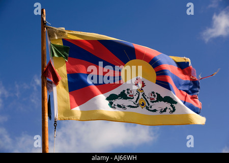 UK Kent Deal tibetische Nationalflagge fliegen im blauen Himmel über Strandhütte Stockfoto